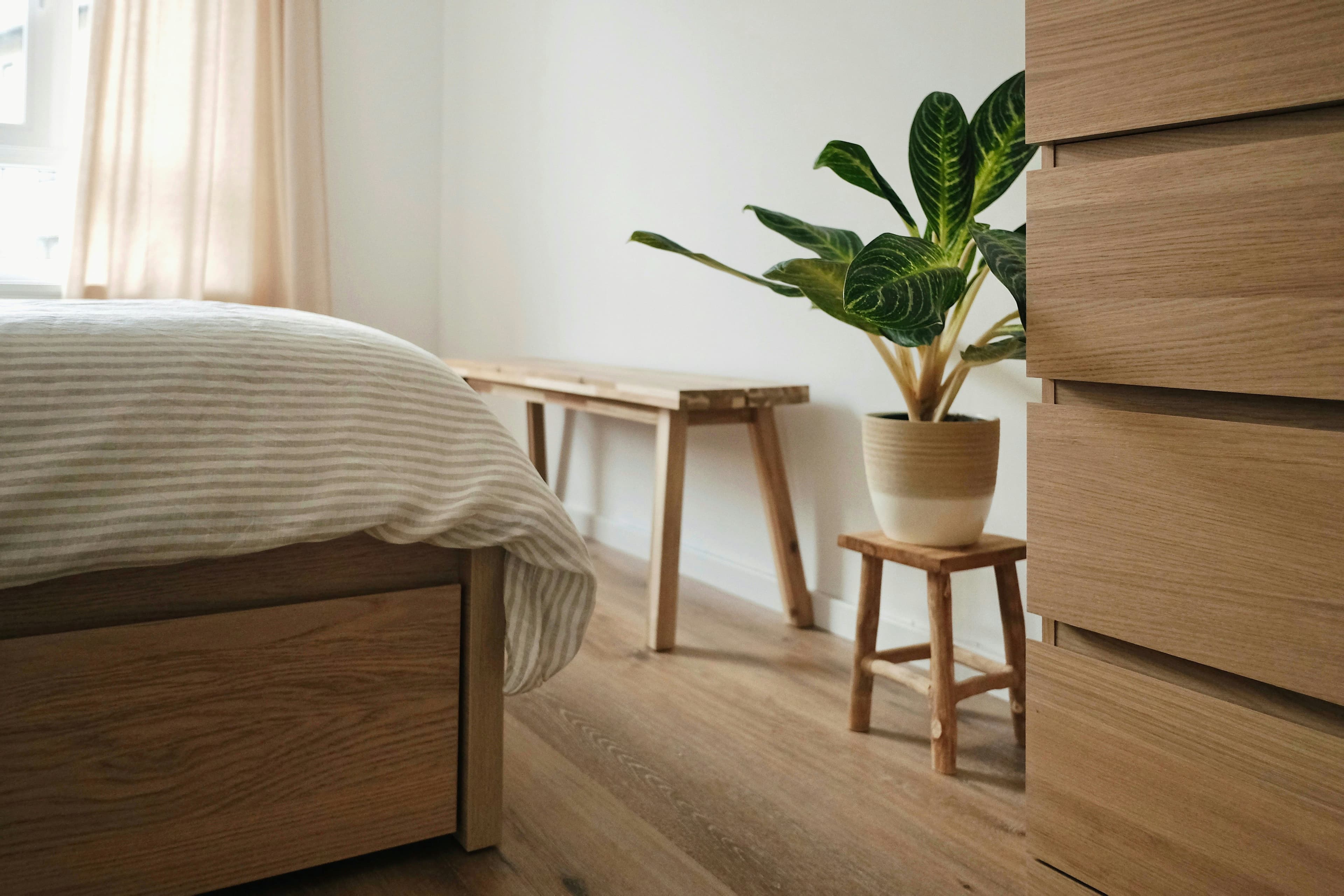 Dormitorio con cama y cajonera de madera clara